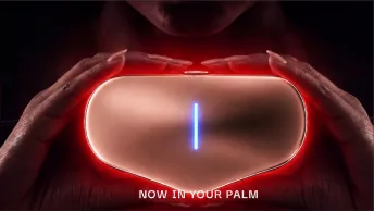 Two hands holding the glowing device.